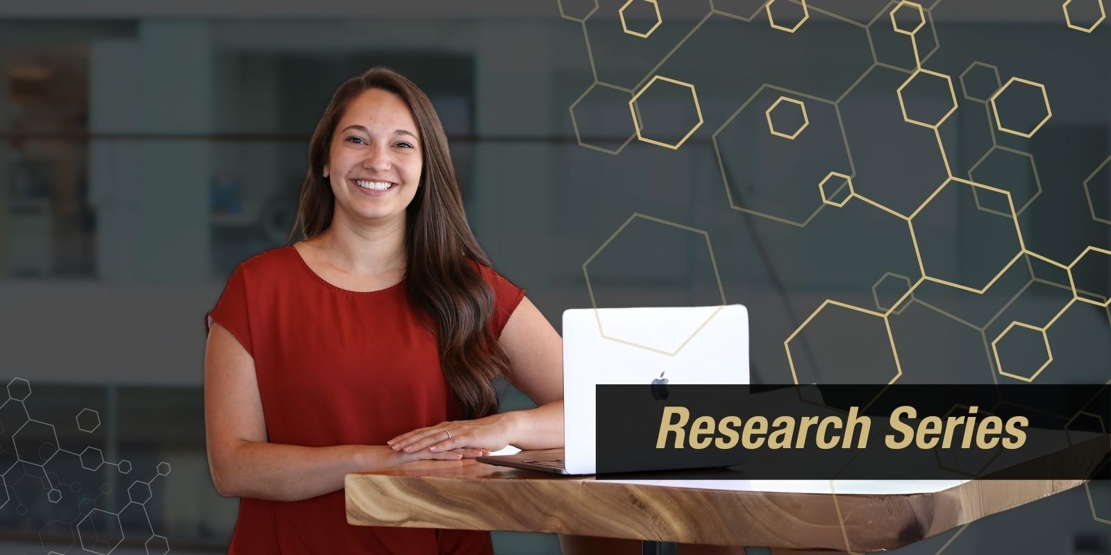Dr. Jessica Clawson poses for a photo with a laptop next to her. Geometric pattern and a banner that says 