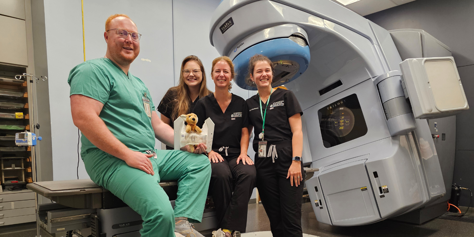 Tristan Seawalt poses with radiation oncology residents/fellows at CSU's Flint Animal Cancer Center at a LINAC radiation-therapy machine used to treat veterinary patients.