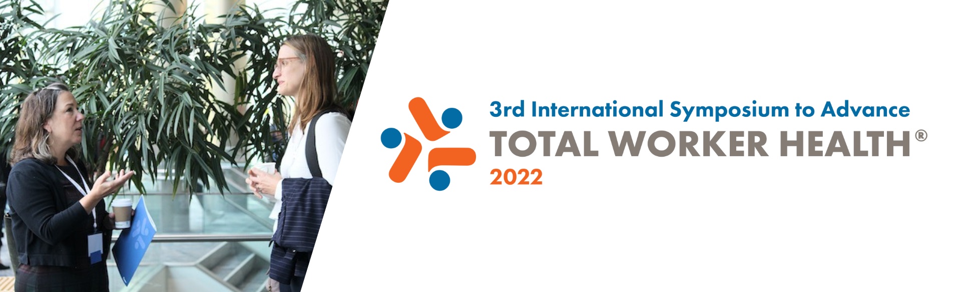 two colleagues talking with international total worker health symposium logo