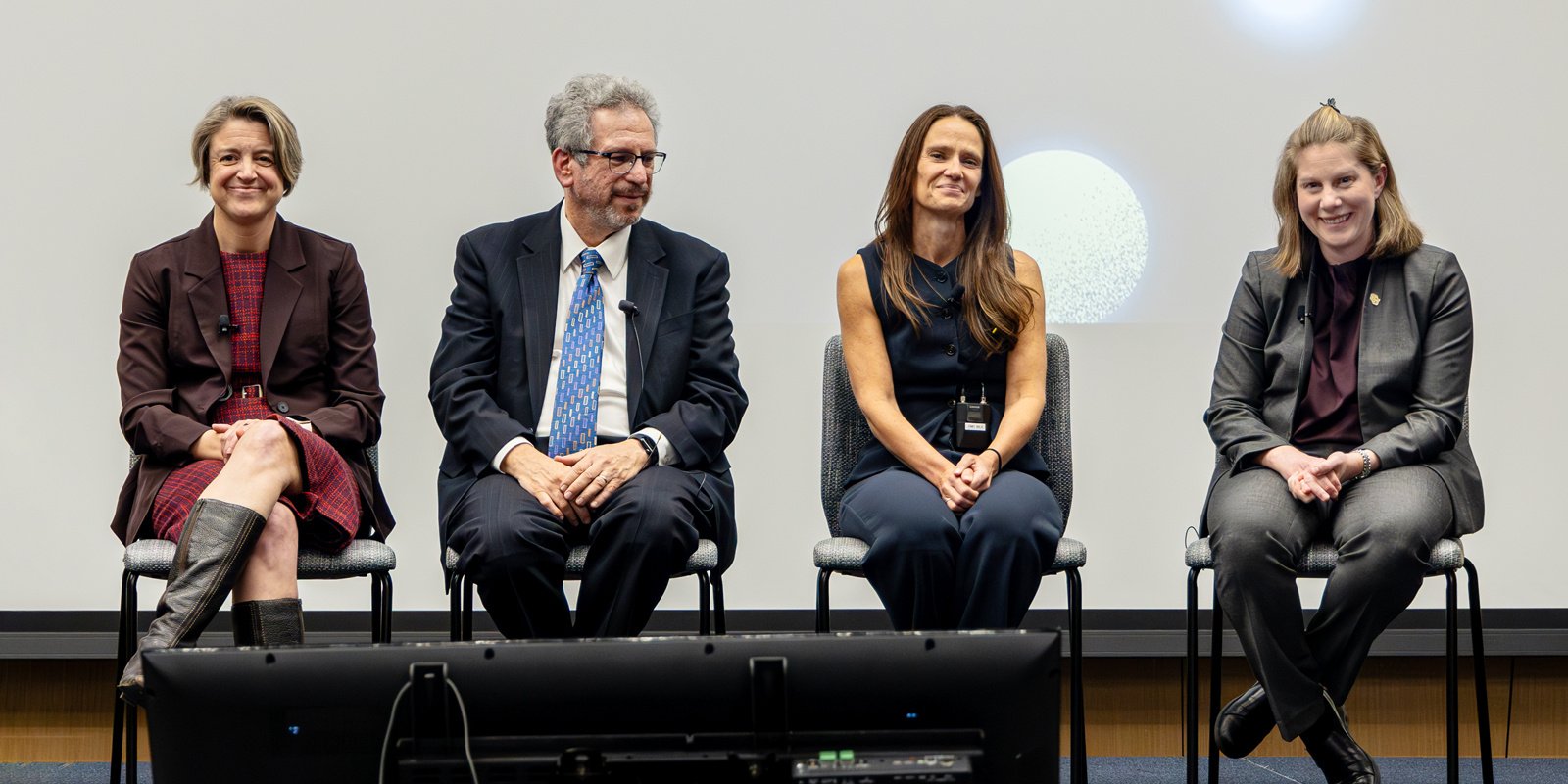 Featured CU School of Medicine faculty from Transforming Healthcare: The Future of Immunotherapy: Breakthroughs Beyond Cancer, sit in chairs on stage. 