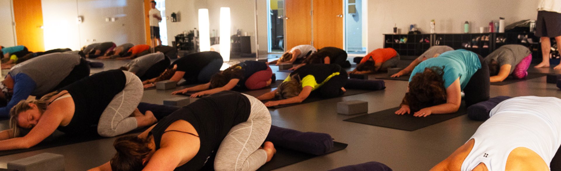 A large class in relaxed yoga pose