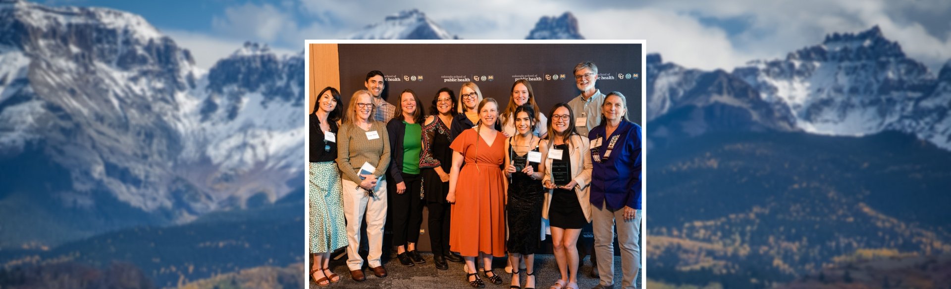 Award recipients lined up smiling with mountain background