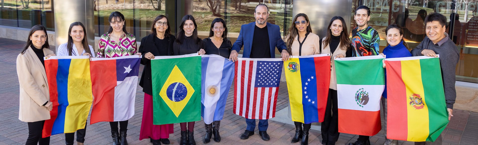 The eleven members of the HTP-Latin America Network and Dr. Joaquin Espinosa standing in a line with flags from their home countries
