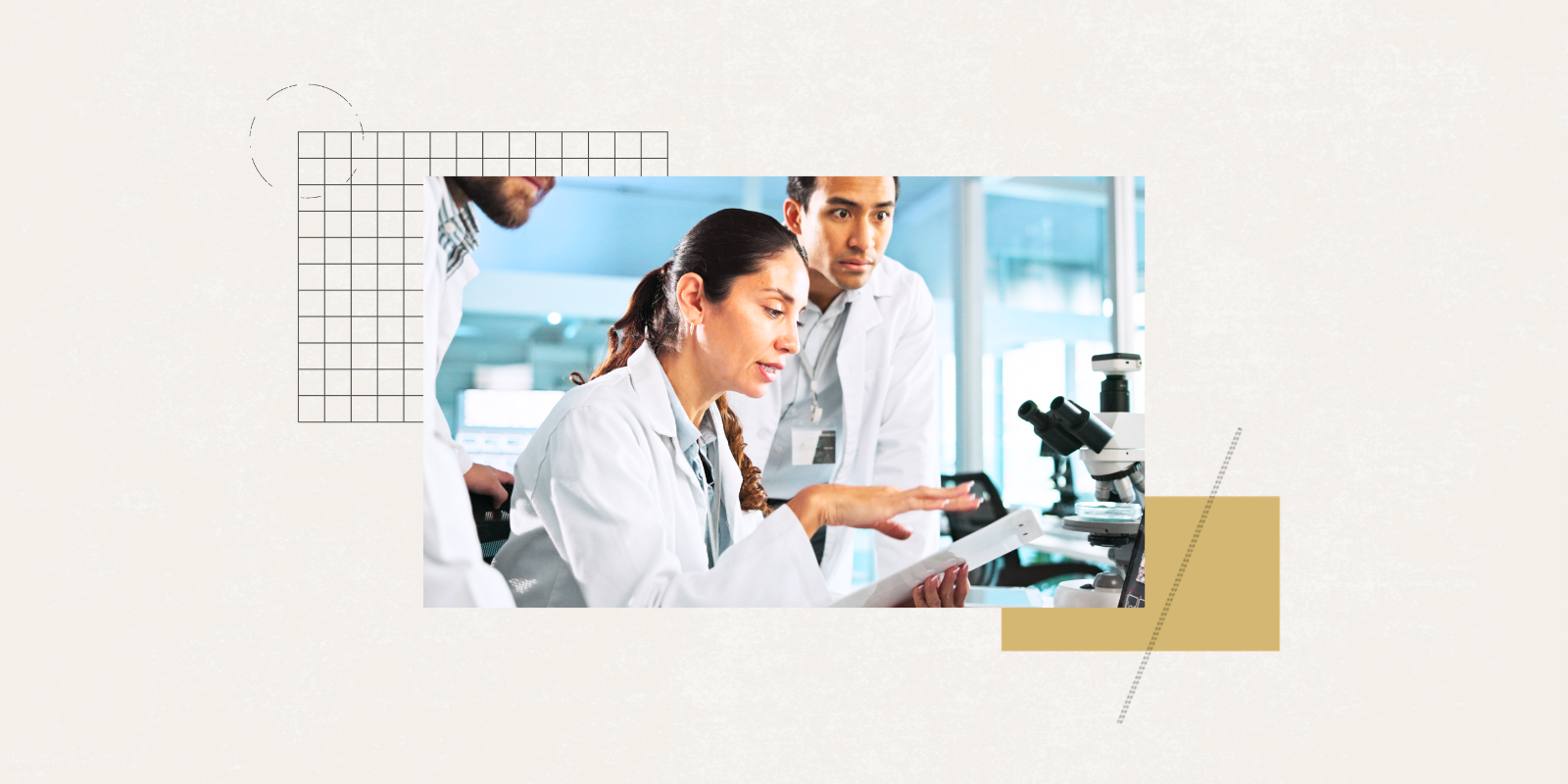 Image of scientists in white coats having a discussion in a lab near a microscope and computer