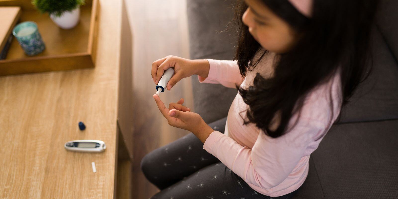 Little girl testing her glucose levels