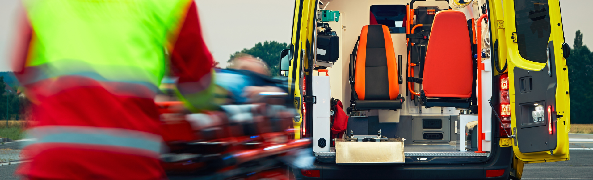 Photo of EMS provider wheeling a patient on a guerney into an ambulance